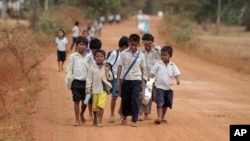 FILE - Cambodian school children walk home after a morning school session at Tnoat Kpoh village in the outskirts of Phnom Penh, Cambodia.