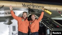 Swiss pilot Bertrand Piccard (R) and alternate pilot Andre Boschberg, also of Switzerland, wave in front of Solar Impulse 2 (Si2), the solar-powered plane, after landing at Tulsa International Airport, Oklahoma, U.S. May 12, 2016.