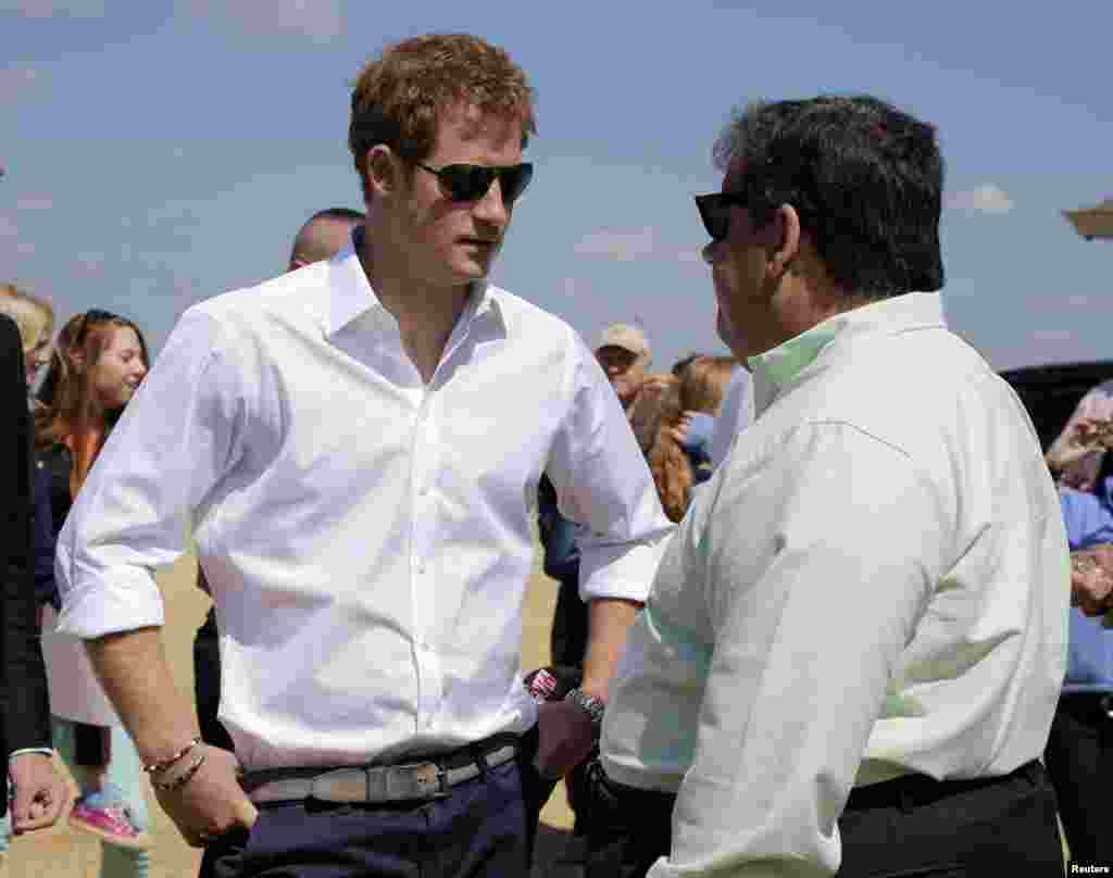 Britain&#39;s Prince Harry and New Jersey Governor Chris Christie (R) talk while visiting the area in Seaside Heights, a beach town hit by Hurricane Sandy last year, in New Jersey, USA.