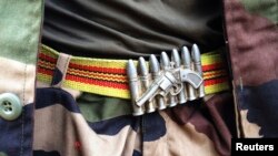 FILE - A soldier from the Seleka rebel coalition wears a belt buckle in the design of a gun and ammunition in Bangui. 