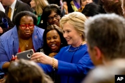 Democratic presidential candidate Hillary Clinton takes pictures with supporters after a campaign event at the Central Baptist Church in Columbia, S.C., Feb. 23, 2016.