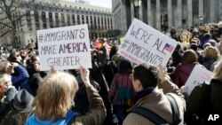 FILE - People hold anti-deportation signs during a rally, March 9, 2017, in New York. The rally was held in support of Ravi Ragbir, leader of the New Sanctuary Coalition, and an immigrant from Trinidad, who may face deportation. 