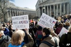 People hold anti-deportation signs during a rally, March 9, 2017, in New York. The rally was held in support of Ravi Ragbir, leader of the New Sanctuary Coalition, and an immigrant from Trinidad, who may face deportation.