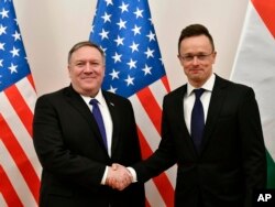Hungarian Minister of Foreign Affairs and Trade Peter Szijjarto, right, shakes hands with US Secretary of State Mike Pompeo in the ministry in Budapest, Hungary, Feb. 11, 2019.