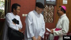 Uskup Agung Semarang Mgr. Robertus Rubiyatmoko menyapa Romo Karl Edmund Prier (tengah) korban luka di kepala akibat penyerangan gereja St.Lidwina, Minggu 11/2 lalu. (Foto: VOA/Munarsih)