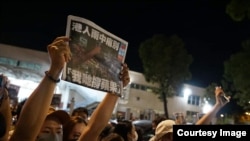 支持者在6月24日凌晨聚集在香港蘋果日報總部外，舉起最後一的《蘋果日報》並高呼支持蘋果的口號（照片來源：美國之音粵語組聽眾鄭先生）