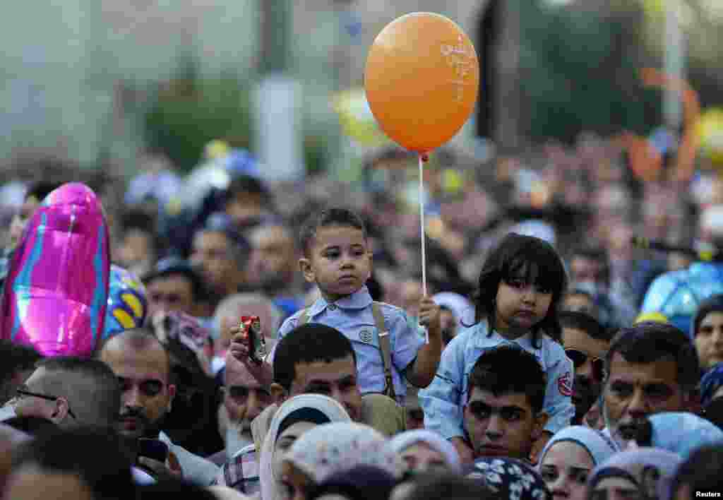 A boy holds a balloon after prayers during the Muslim holiday of Eid al-Fitr, in Jerusalem&#39;s Old City, July 28, 2014.