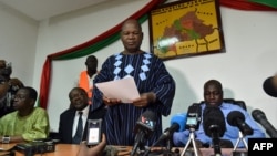 Opposition leader Jean Hubert Bazie (C) reads a statement, next to the head of Burkina Faso's opposition Zephirin Diabre (D), during a press conference on Nov. 1, 2014 in Ouagadougou. 