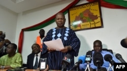 Pemimpin oposisi Jean Hubert Bazie (tengah) membacakan pernyataan, di samping ketua oposisi Burkina Faso Zephirin Diabre, dalam konferensi pers pada 1 November 2014 di Ouagadougou. 