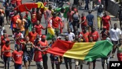 Des Guinéens avec leur drapeau national manifestent pacifiquement contre le troisième mandat du président guinéen, le 7 novembre 2019 à Conakry. (Photo par CELLOU BINANI / AFP) 