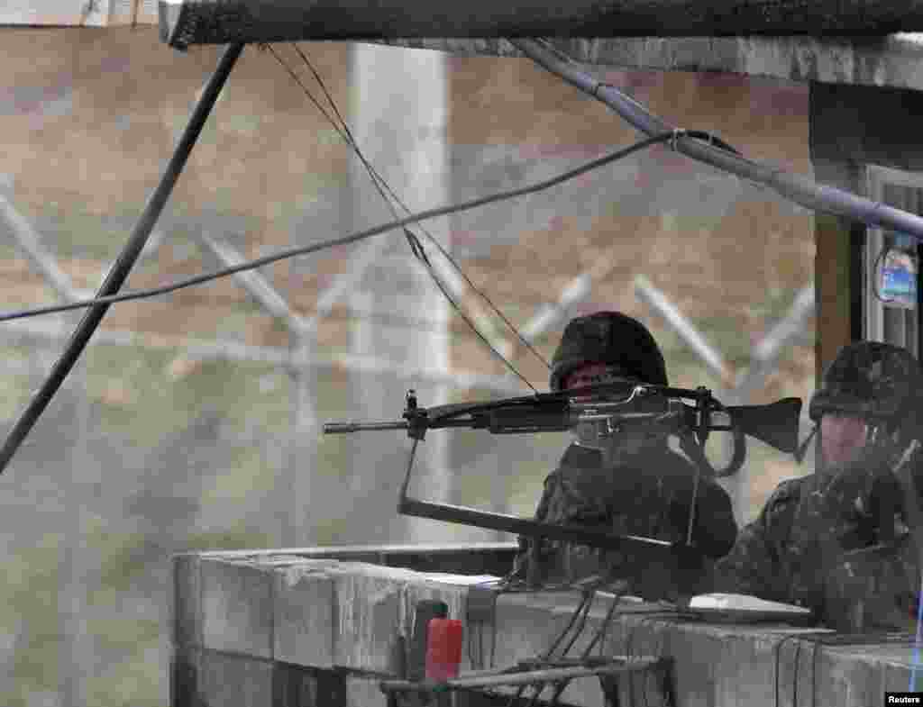 South Korean soldiers stand guard at an observation post near the demilitarized zone (DMZ) which separates the two Koreas in Paju, north of Seoul April 11, 2013. 