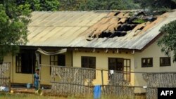 Une femme devant le toit endommagé du dortoir d'une école, après que celle-ci ait été incendiée pendant la nuit à Bafut, Cameroun, le 15 novembre 2017.