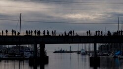 People watch the water rise in the Santa Cruz harbor in Santa Cruz, Calif., Jan. 15, 2022.