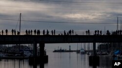 People watch the water rise in the Santa Cruz harbor in Santa Cruz, Calif., Jan. 15, 2022.