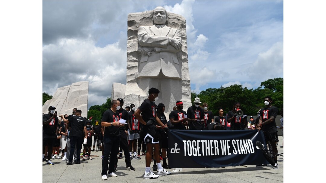 Para demonstran berkumpul di sekitar patung Martin Luther King, Jr. menandai peringatan "Juneteenth" di Washington, DC, 19 Juni 2020.