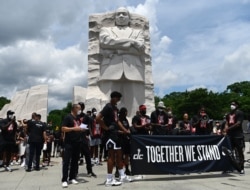 Para demonstran berkumpul di sekitar patung Martin Luther King, Jr. menandai peringatan "Juneteenth" di Washington, DC, 19 Juni 2020.