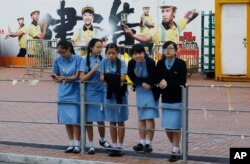 FILE - Pro-democracy high school students chat in the occupied area outside government headquarters in Hong Kong's Admiralty on Oct. 28, 2014.