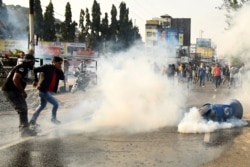 Para demonstran berlari saat polisi menembakkan gas air mata untuk membubarkan aksi protes RUU Amandemen Kewarganegaraan (CAB) pemerintah, di Guwahati, 11 Desember 2019.