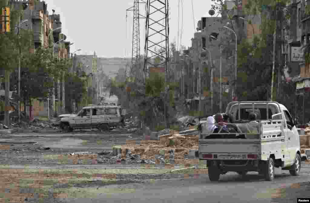 People travel on the back of a pickup truck in Deir al-Zor, Syria, May 19, 2013. 