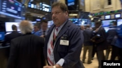 Traders work on the floor of the New York Stock Exchange July 14, 2015. 