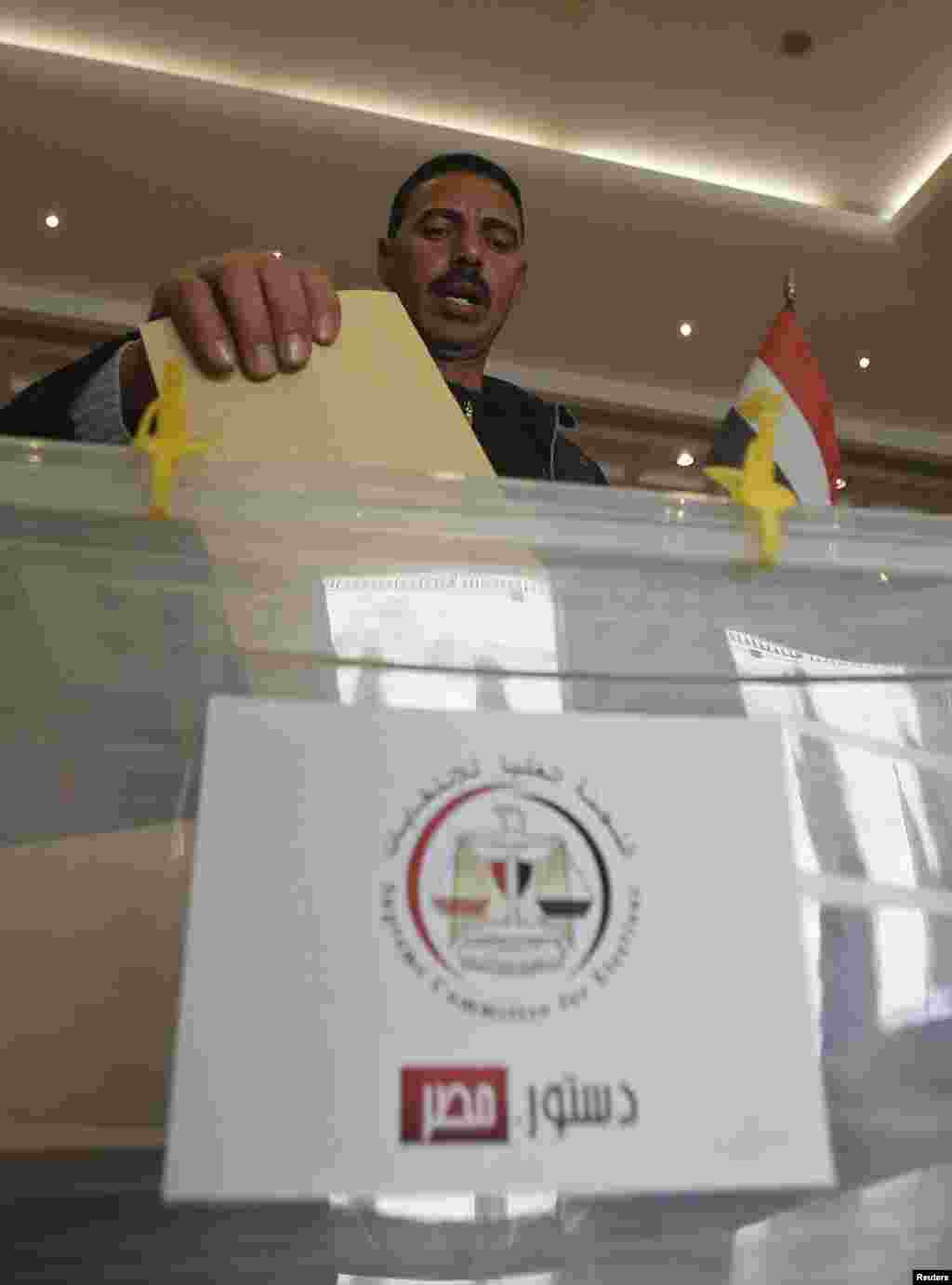 An Egyptian votes on the new Egyptian constitution at the Egyptian embassy in Amman December 12.