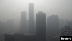 Bangunan pencakar langit di pusat bisnis di Beijing nampak tenggelam di dalam kabut asap tebal yang menyelimuti Tiongkok, 14 Januar 2013. (REUTERS/Jason Lee)