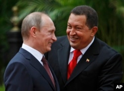 FILE - Venezuela's President Hugo Chavez, right, and Russia's Prime Minister Vladimir Putin speak during a welcoming ceremony at Miraflores Presidential Palace in Caracas, April 2, 2010