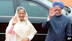 Indian Prime Minister Manmohan Singh (R) and Bangladeshi Prime Minister Sheikh Hasina (L) wave to media, 11 Jan 2010