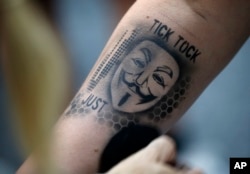 FILE - An attendee gets an airbrushed tattoo during the Black Hat conference, Aug. 6, 2015, in Las Vegas.