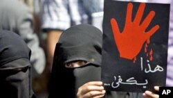 A Yemeni anti-government protester holds up a placard that reads 'This is enough' during an anti-regime demonstration calling on President Ali Abdullah Saleh to leave in the capital Sana'a, February 24, 2011
