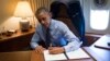 President Barack Obama signs two presidential memoranda associated with executive actions on immigration from his office on Air Force One upon his arrival in Las Vegas, Nevada, Nov. 21, 2014.