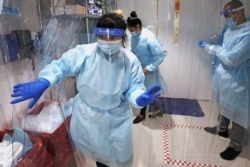 Lena Landaverde, assistant director of the Precision Diagnostics Center, heads to the new COVID-19, on-campus testing labs after donning personal protective equipment, Thursday, July 23, 2020, at Boston University in Boston.