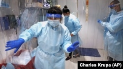 Lena Landaverde, assistant director of the Precision Diagnostics Center, heads to the new COVID-19, on-campus testing labs after donning personal protective equipment, Thursday, July 23, 2020, at Boston University in Boston.