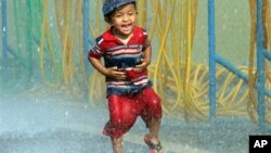 ရန်ကုန် မြို့တော်ခန်းမ သင်္ကြန်မဏ္ဍပ်ဖွင့်ပွဲအတွင်း ရေပိုက်တွေကြားမှာ ပြေးလွှားပျော်ရွှင်နေတဲ့ ကလေးငယ်တဦးကို တွေ့ရစဉ်။ (ဧပြီ ၁၃၊ ၂၀၁၅)
