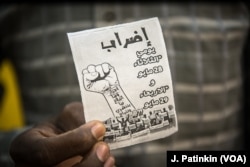An employee of mobile phone company MTN holds a flyer supporting a general strike which he hands out to potential customers before turning them away, in Khartoum, Sudan, May 28, 2019.