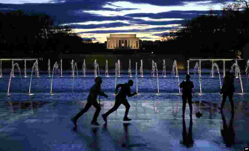 Tourists visit the National World War II Memorial on the east end of the Reflecting Pool and Lincoln Memorial as a storm clears the nation's capital in Washington.
