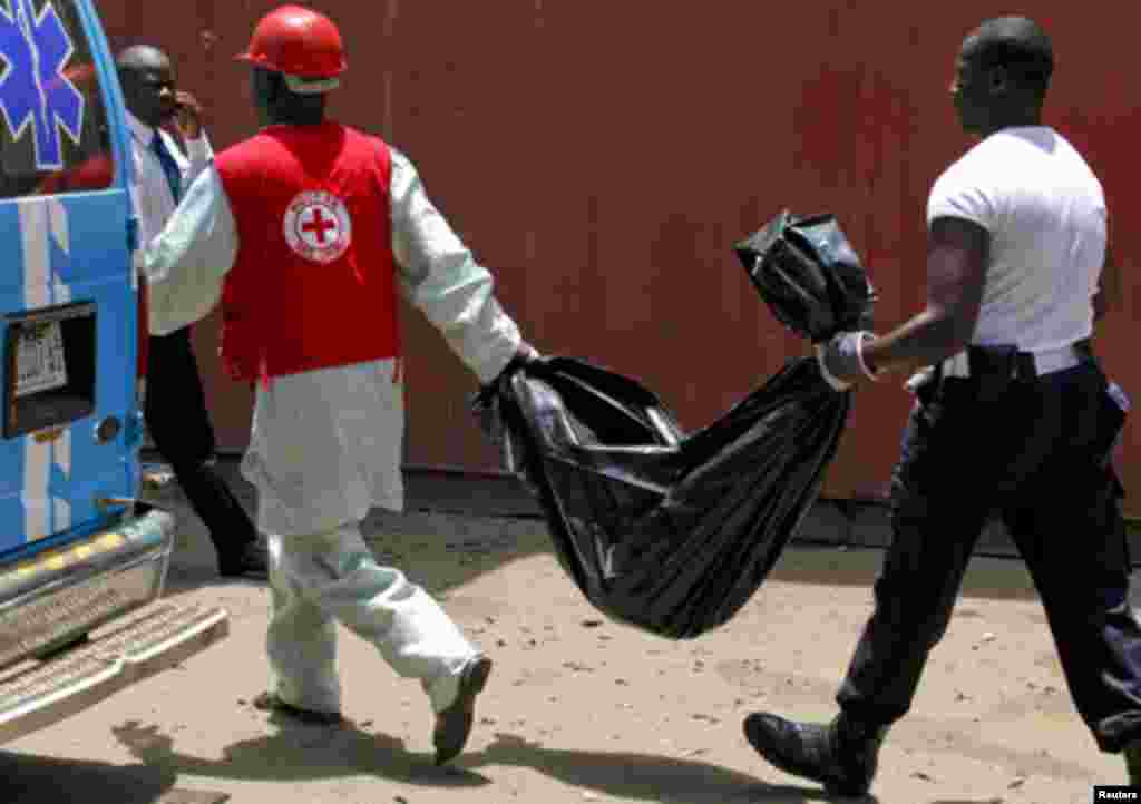Rescue officials recover mangled bodies, wrapped in black polythene, at the site of a bomb blast at the premises of Nigerian newspaper This Day in Abuja April 26, 2012