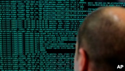 一名法國軍人在他位於法國國防部的電腦前觀看編碼線。(2018年1月23日)