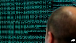 FILE - A French soldier watches code lines on his computer during the International Cybersecurity forum in Lille, northern France, Jan. 23, 2018. 