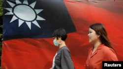 人們從台北街頭的台灣旗幟旁走過。 （2020年8月10日）