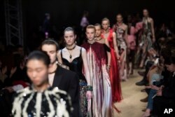 Models wear creations for the Alexander McQueen ready-to-wear fall/winter 2018-19 fashion collection presented in Paris, March 5, 2018.