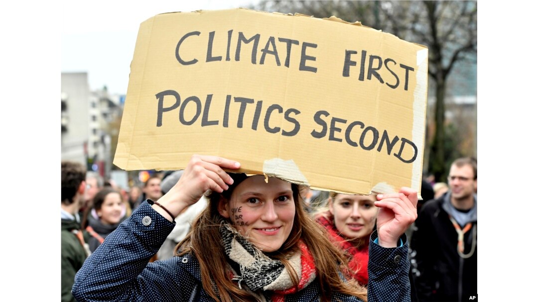 Una manifestante sostiene un cartel que dice "El clima primero, luego la política", durante una marcha en Bruselas el domingo 2 de diciembre de 2018.