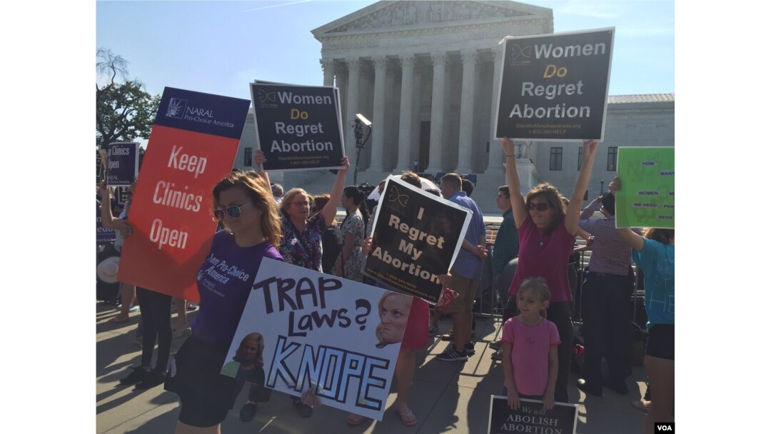 Pro-life and pro-choice demonstrators wave signs and make their voices heard after the Supreme Court upheld abortion rights in a 5-3 decision, in front of the Supreme Court building in Washington, June 27, 2016. (J. Oni / VOA News)