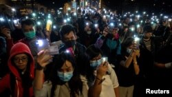 Фото: мітингарі увімкнули ліхтарики мобільних телефонів на підтримку протестувальників, яких оточила поліція на території місцевого політехнічного унверситету