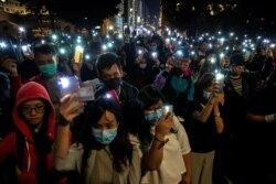 Protesters raise their mobile phones with lights on as they gather to show their support for protersters who are still inside the campus of the Hong Kong Polytechnic University (PolyU) in Hong Kong, China, November 19, 2019.