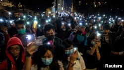 Người biểu tình bật đèn điện thoại bày tỏ tình đoàn kết với những người biểu tình bị cảnh sát bao vây bên trong đại học Bách Khoa Hong Kong ngày 19/11/19. 