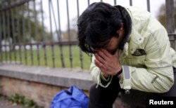 FILE - Omar, a 27-year-old cook originally from Deraa, the cradle of the Syrian uprising against Bashar Al-Assad, sits in front of the asylum processing centre in Traiskirchen, Austria, Oct. 13, 2015.