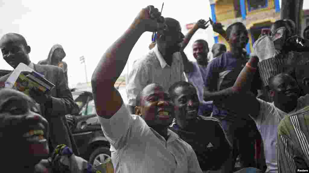 &#39;Yan Najeriya dauke da tsintsiya da ruwa, Lagos, Maris 31, 2015.