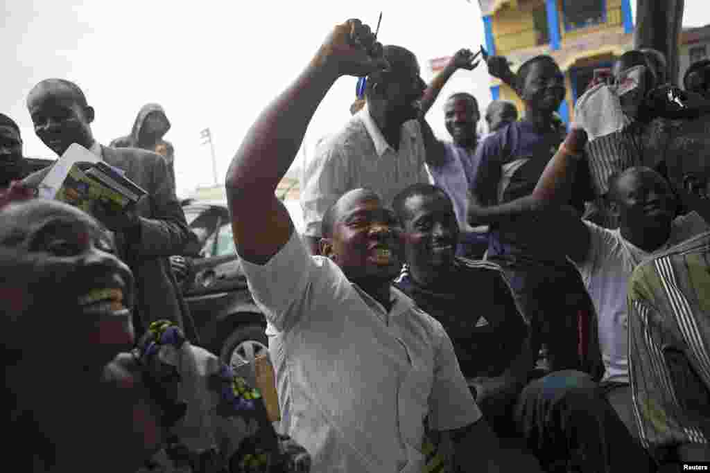 Supporters of presidential candidate Muhammadu Buhari cheer as they watch news coverage of election results favorable to them on a street in Lagos, March 31, 2015.