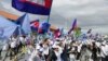 FILE - Supporters of the opposition party, Candlelight Party, wave flags as they take part in a campaign rally for the upcoming local elections on June 5, in Phnom Penh, Cambodia May 21, 2022. Picture taken May 21, 2022. REUTERS/Prak Chan Thul